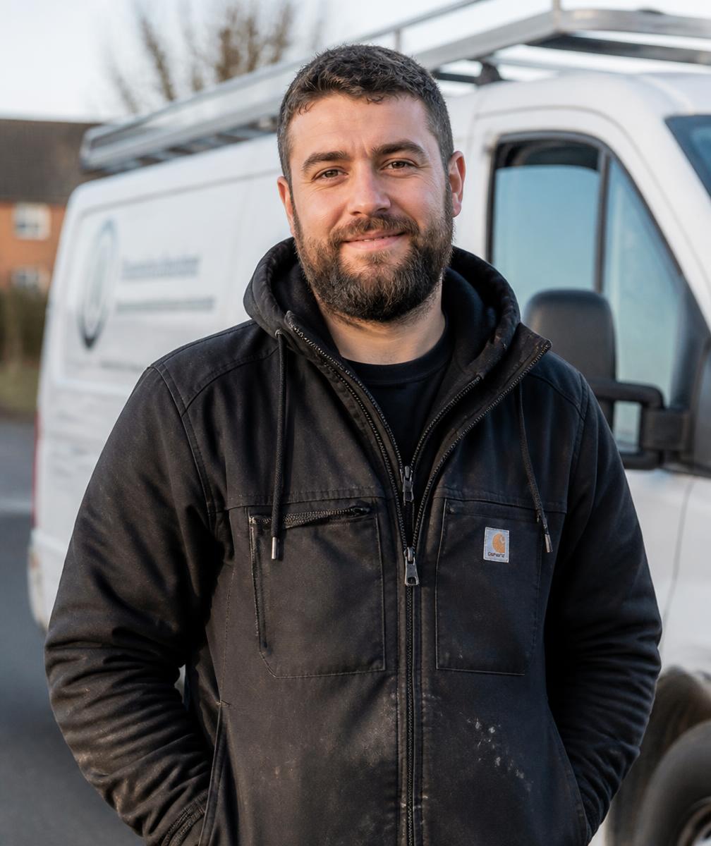 Portrait des Inhabers in Arbeitskleidung vor dem Transporter